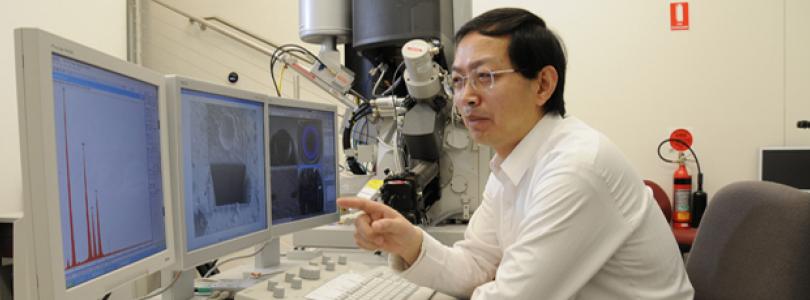 person sitting in front of an electron microscope